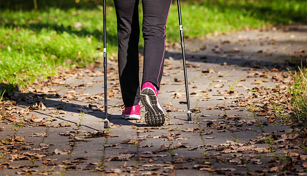 Nordic walking Nordic walking adventure and exercising concept - woman hiking withnordic walking poles in park nordic countries stock pictures, royalty-free photos & images
