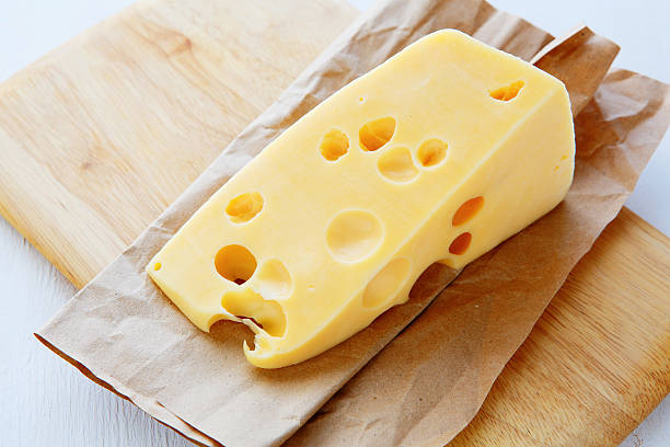 piece of cheese with holes stock photo