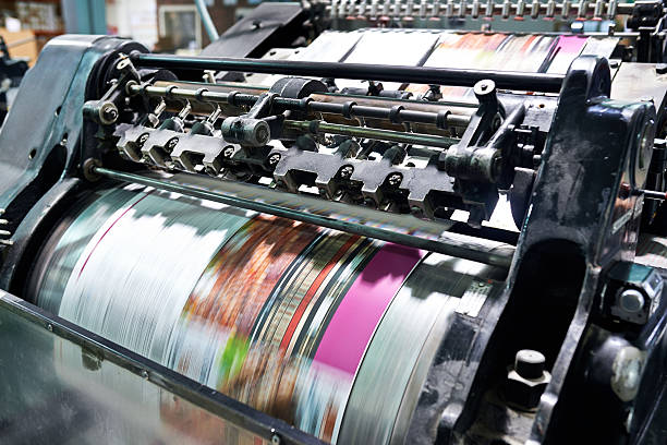 Printing at high speed Detail shot of the workings of a printing factory. The commercial designs displayed in this image represent a simulation of a real product and have been changed or altered enough by our team of retouching and design specialists so that they are free of any copyright infringements digital printing house stock pictures, royalty-free photos & images
