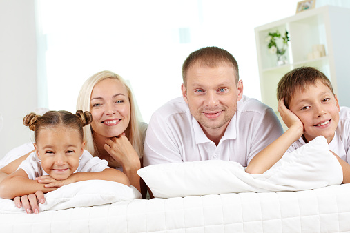 Portrait of happy parents with two children having rest at home