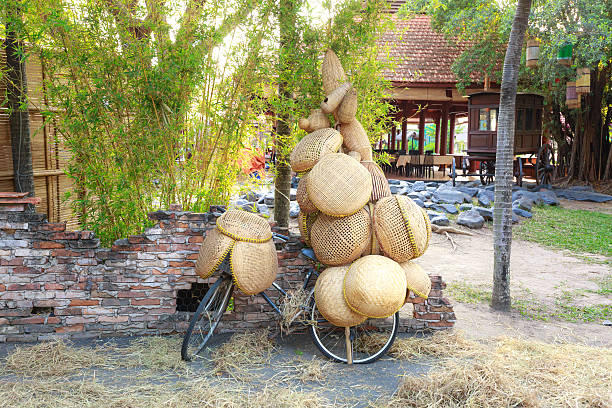 Weaving bamboo products on bicycle to sell on street.  those tools are used in kitchen and catch fish is traditional occupation of Vietnam farmers