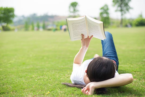 istock beautiful girl with book on the grass 519920928