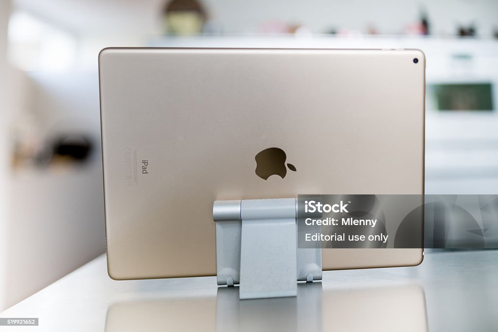 Modern Living Room with Apple iPad Pro Gold Stuttgart, Germany - April 10, 2016: The big sized Apple iPad Pro 12.9 " 32GB Wifi  Gold Colored Version standing in horizontal position inside aluminium docking station on steel metal table in living room kitchen. Digital Tablet Stock Photo