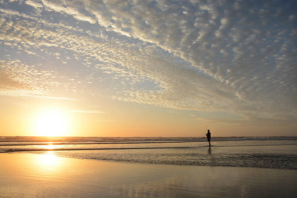 istock Man walking on the beach at sunrise. 519922484