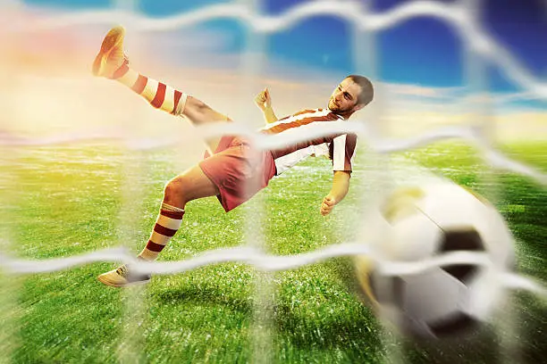 Football player kicking the ball to the goal