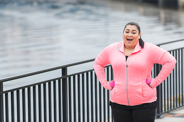 istock Overweight Hispanic woman exercising with handweights 519925700