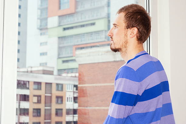 istock Man looking on city through the window 519926688