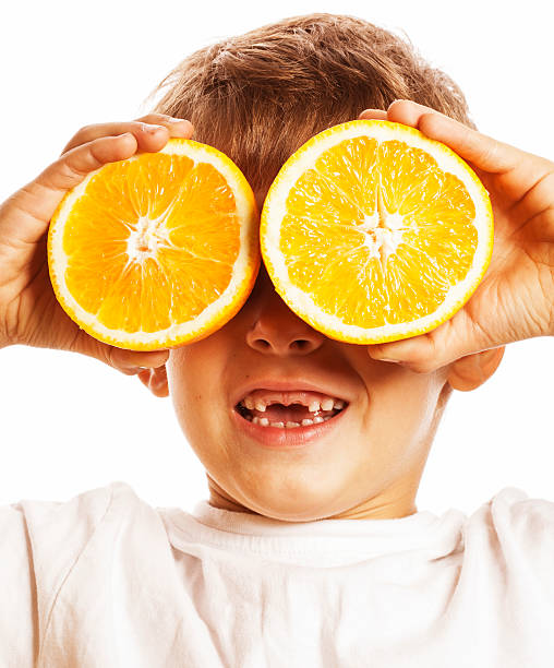 istock little cute boy with orange fruit double isolated on white 519927120