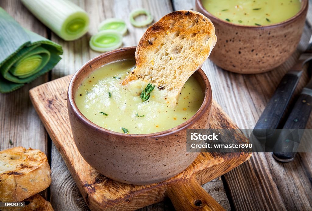 homemade cream of leek soup with croutons homemade cream of leek soup with croutons on wooden table Vichyssoise Stock Photo