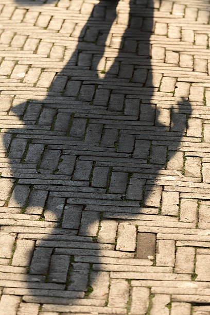 istock sun casting shadow over someone walking on the street 519934235