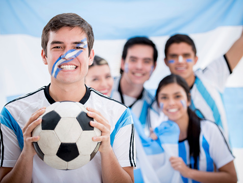 Man with a group of soccer fans cheering for Argentina