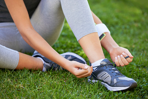Cropped shot of a runner tying her shoelaces