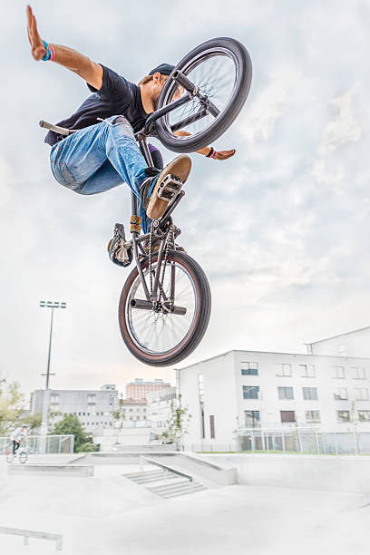 BMX biker BMX biker performing a stunt in ramp park. bicycle stunts stock pictures, royalty-free photos & images