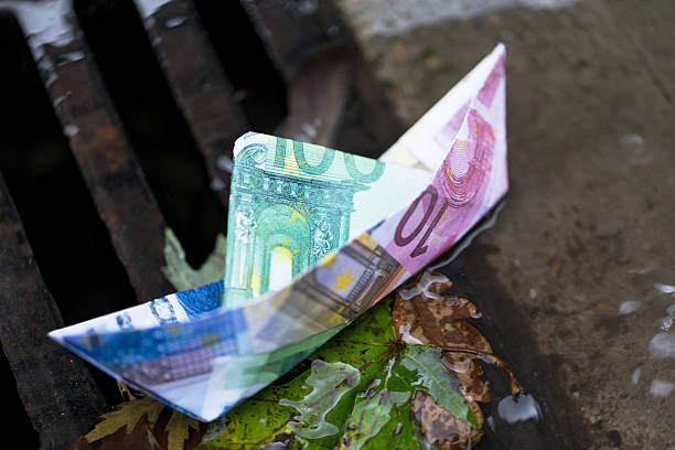 Euro paper boat Paper boat made of different euro notes, going down the drain five euro banknote photos stock pictures, royalty-free photos & images