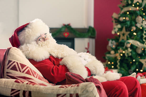 istock Santa Claus sitting on a red couch 519938251