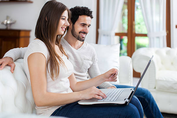 istock Happy couple using a laptop on the sofa 519956156