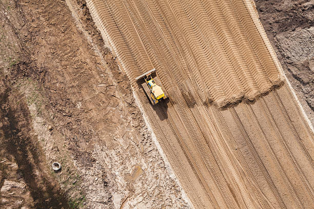 空から見た動作ショベル��カー - earth mover working field dirt ストックフォトと画像