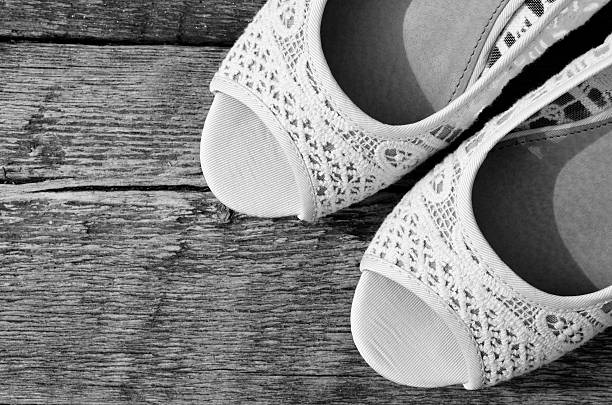 A black and white image of ladies lace high heeled shoes.