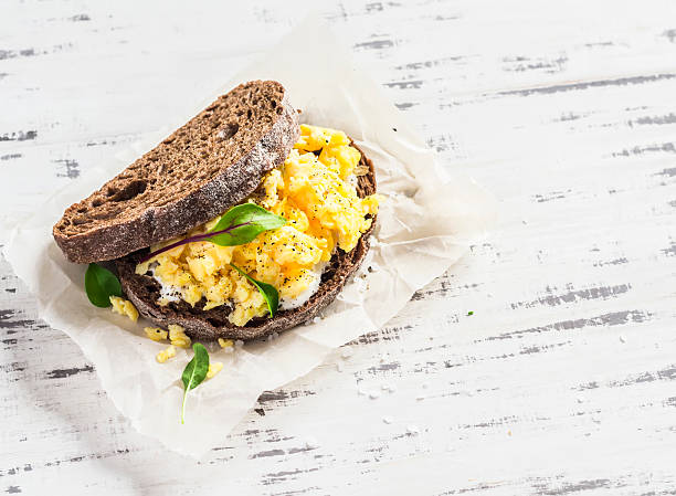 istock Scramble egg sandwich on  a light  wooden background 519963092