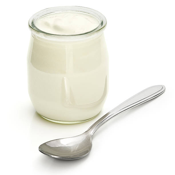 Yogurt A jar of plain yogurt with a silver spoon. yogurt stock pictures, royalty-free photos & images