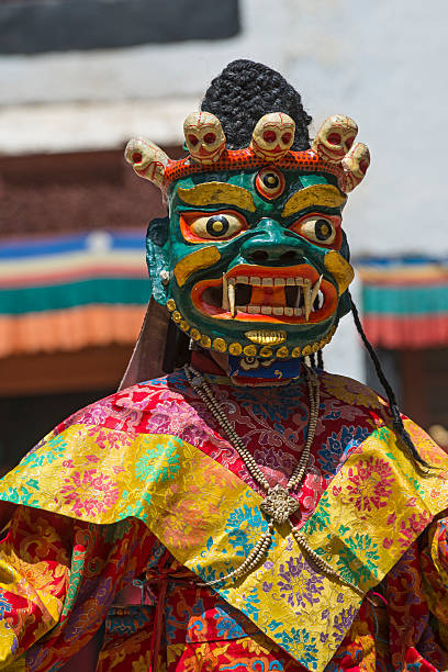 Buddhist monk is performing a sacred dance in Ladakh. Phyang, India - July 15, 2015: Buddhist monk is performing a sacred dance in the courtyard of Phyang Monastery, Ladakh. He is dressed in a traditional costume and is wearing  an old mask.  phyang monastery stock pictures, royalty-free photos & images