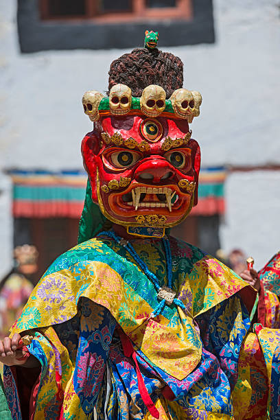 Buddhist monk is performing a sacred dance in Ladakh. Phyang, India - July 15, 2015: Buddhist monk is performing a sacred dance in the courtyard of Phyang Monastery, Ladakh. He is dressed in a traditional costume and is wearing  an old mask.  phyang monastery stock pictures, royalty-free photos & images