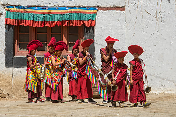 Buddhist monks are playing music during festival in Ladakh. Phyang, India - July 15, 2015: Buddhist monks are performing traditional music during in a festival in the courtyard of Phyang Monastery, Ladakh. They are dressed in traditional costumes. phyang monastery stock pictures, royalty-free photos & images
