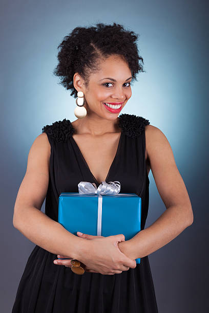 istock Young African American woman holding a gift 519971521