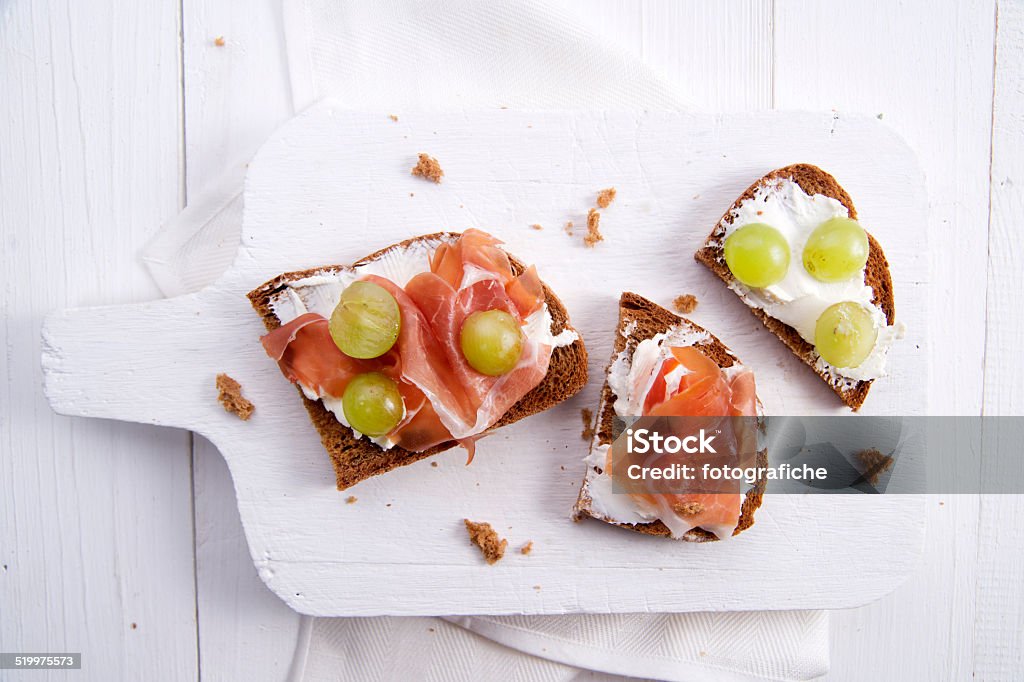 Bread, cheese and ham and grapes Snack of whole grain bread with soft cheese and ham and sweet grape Bread Stock Photo