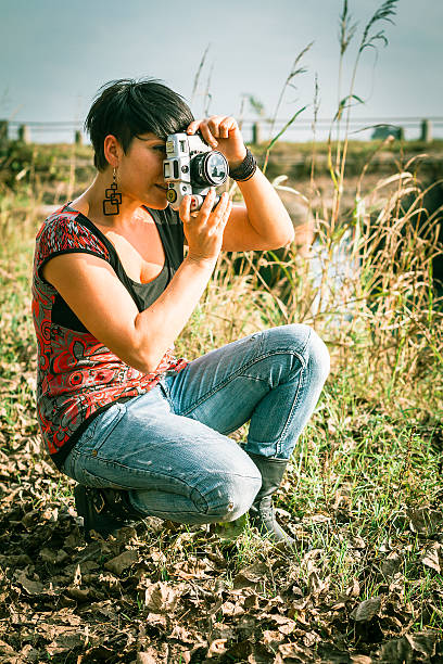 istock Young woman taking picture with old camera 519976515
