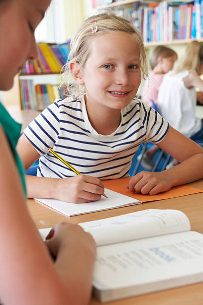 istock Elementary School Pupil Working At Desk In Classroom 519977071