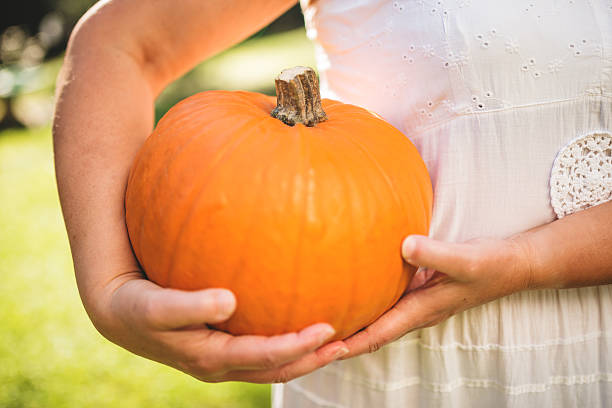 istock woman holding an halloween pumpkin 519977679