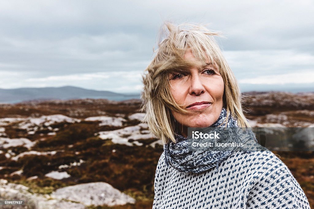 Outdoor Hebridean portrait of a woman Head and shoulders portrait of an adult woman on the open empty landscape of the Isle of Lewis and Harris on a raw windy day. AdobeRGB colorspace. Extreme Terrain Stock Photo