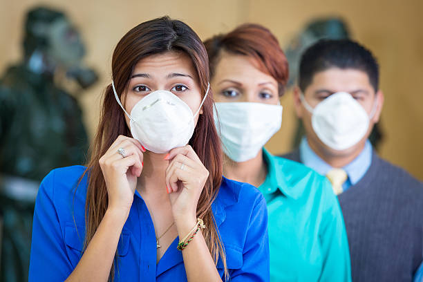 zróżnicowane businesspeople w medycznych maska na twarz zabezpieczającej w sezonie grypowym - toxic waste radiation protection suit chemical protective suit zdjęcia i obrazy z banku zdjęć