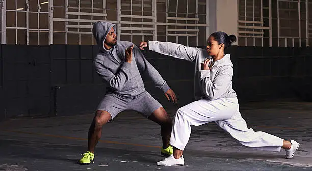 Shot of a young man and woman practicing martial arts together