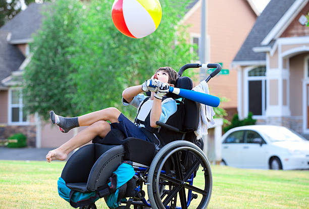 Ragazzo disabile colpire palla e mazza sul parco - foto stock