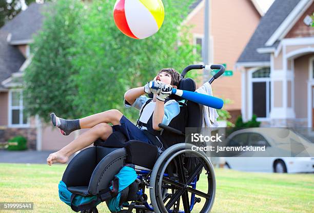 Disabled Boy Hitting Ball With Bat At Park Stock Photo - Download Image Now - Child, Disability, Wheelchair