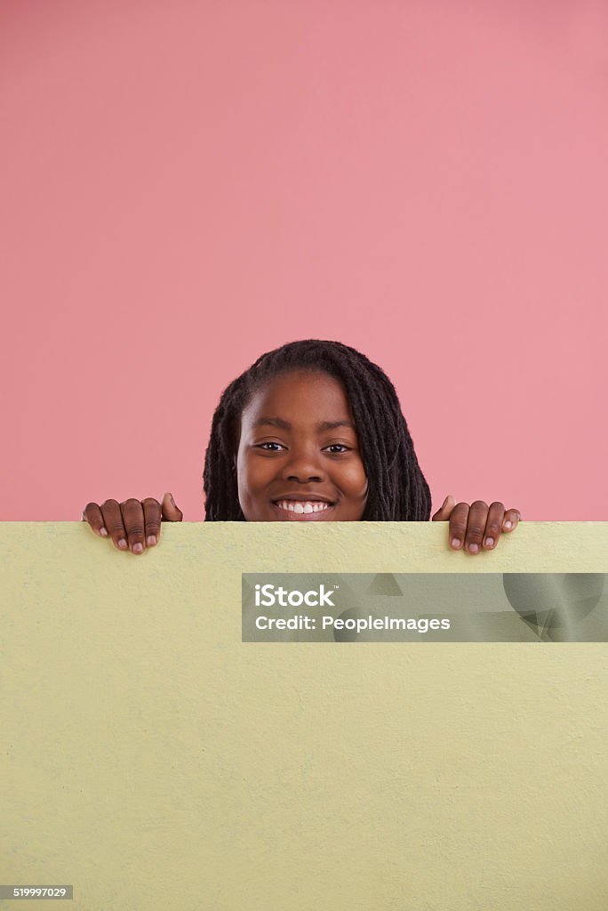 It's the in-thing Studio shot of a young boy standing behind a blank signboard Behind Stock Photo