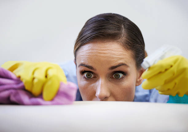 Can't believe I didn't see you before Shot of a young woman shocked by the dirt she is finding around her house. obsessive stock pictures, royalty-free photos & images