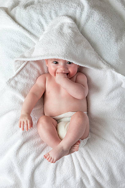 sonriente bebé en manta lying - covered nudity fotografías e imágenes de stock