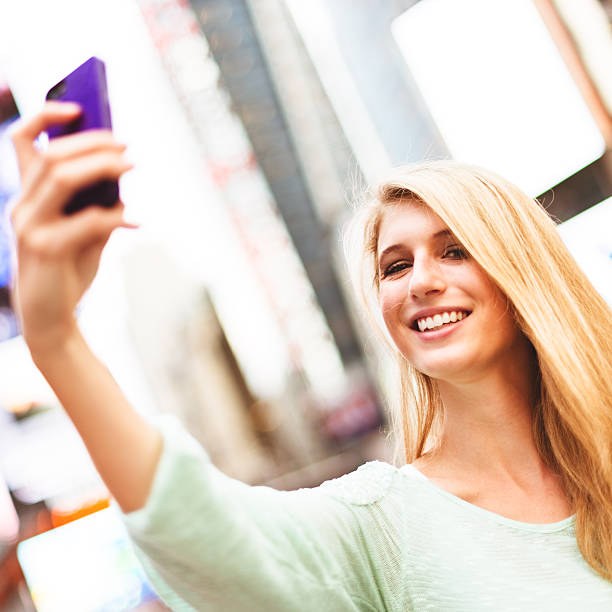 istock woman self photographing in times square - NYC 519999607
