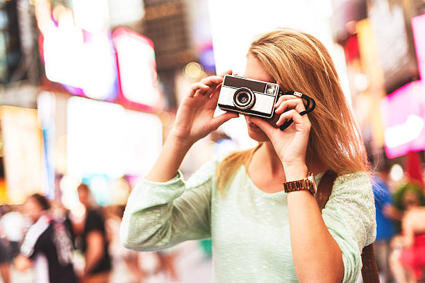 istock pretty woman smiling on times square with camera 519999623