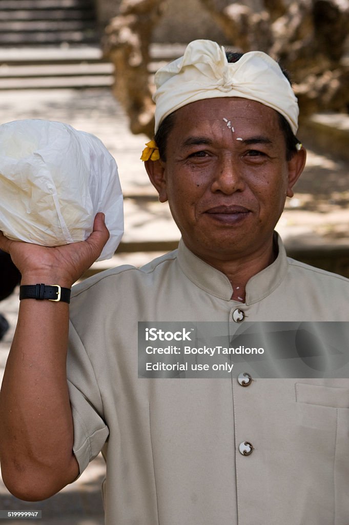 Balinese Man Uluwatu,Bali,Indonesia - Sept 8th, 2007. A Balinese man at Uluwatu Temple Compound, holding a bag of ceremonial rice that was blessed by priest. Rice is not only a staple diet, but is also an essential part of social and religious ceremonies. Balinese Culture Stock Photo