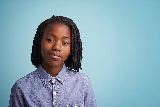 This boy's got confidence Portrait of a young boy standing against a blue background confident boy stock pictures, royalty-free photos & images