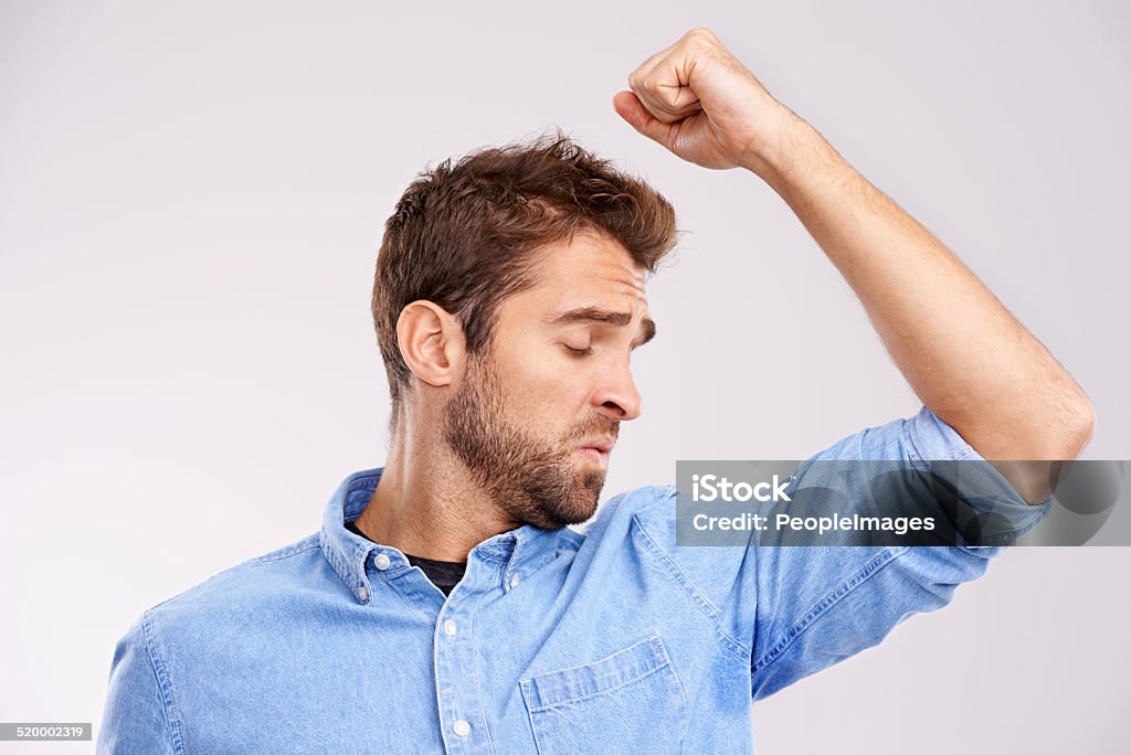 Wow, is that me? Studio shot of a handsome young man smelling his sweat-soaked armpits against a gray background Armpit Stock Photo