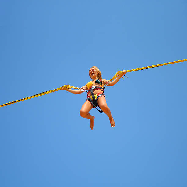 istock jumping girl on the trampoline at  funfair 520003178