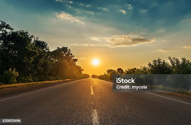 Sol En Horizon Mientras Carretera Asfaltada Foto de stock y más banco de imágenes de Vía - Vía, Largo - Longitud, Salida del sol