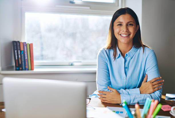 istock Confident grinning woman at desk behind laptop 520003840
