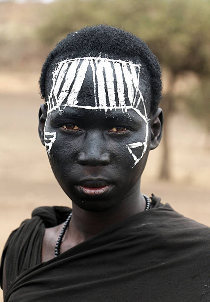 Karatu, Tanzania – October 7, 2015: Portrait of unidentified Masai warrior with his traditional face painting after being circumcised as a rite of passage to adulthood.