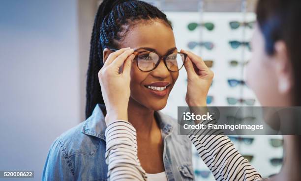 Photo libre de droit de Séduisante Jeune Femme Africaine En Sélectionnant Des Lunettes banque d'images et plus d'images libres de droit de Lunettes de vue